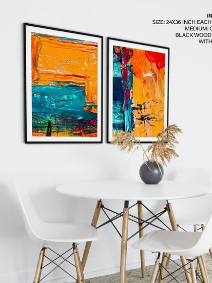 A minimalist dining or workspace featuring our set of two colorful abstract prints. The simple black frames complement the modern furniture and allow the bold artwork to take center stage.