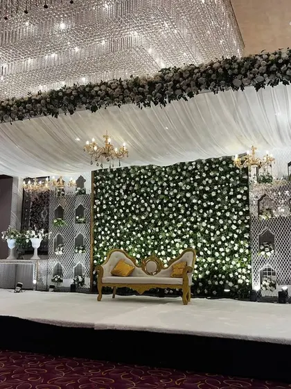 The magnificent stage for a Nikaah or reception at Crowne Plaza. The design features a massive floral border, white draped ceiling, and an elegant backdrop with a flower wall.