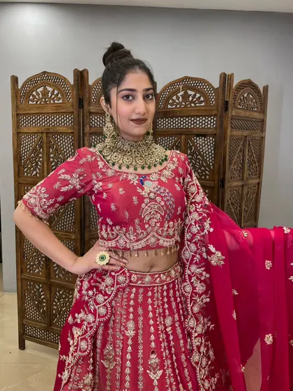 This vibrant pink lehenga with heavy gold jewelry is a stunning bridal or festive look.