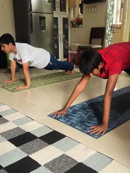 Two boys hold a strong plank pose, a simple yet powerful exercise for building full-body strength and endurance.