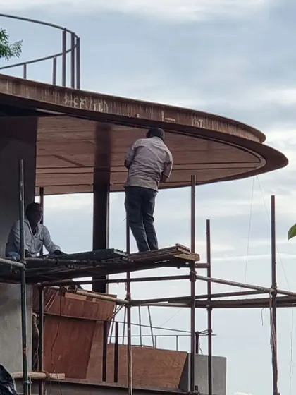 (Duplicate of 88) Workers on the scaffolding give a sense of scale to the large, sweeping canopy of the roof, a testament to the human effort required to realize an architectural vision.