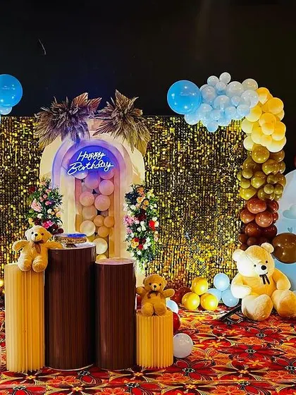 A teddy bear theme with a shimmering gold sequin wall and a 3D panel for a touch of glamour.