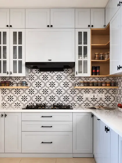 This kitchen showcases a refined neutral theme with subtle grey shaker cabinets and a striking black-and-white patterned tile backsplash. I incorporated open veneer shelves to bring warmth and provide easy access to spices and everyday items.