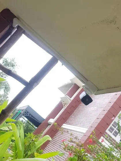 A camera tucked neatly under an eave, demonstrating a discreet installation approach.