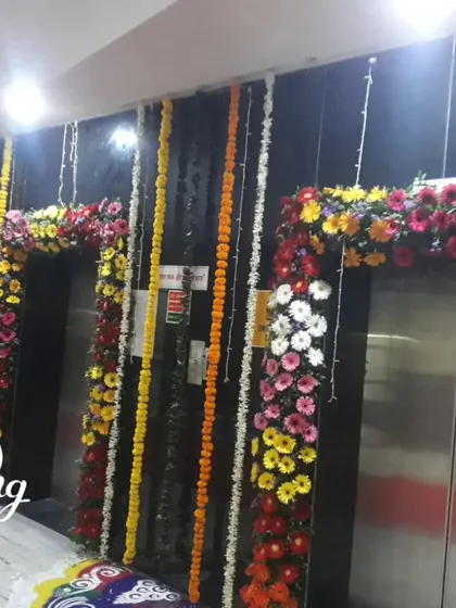 Elevator doors decorated with arches of fresh, colorful flowers for a celebration in a residential or commercial building.