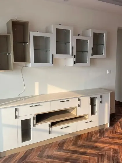 A custom-designed crockery and entertainment unit. It features a mix of open shelves and glass-front cabinets, providing versatile storage and display options.