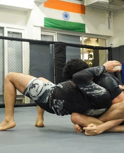 A fighter working to secure a back-take, a dominant position in Jiu Jitsu. We drill these high-percentage techniques relentlessly.