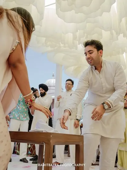 Guests participate in a traditional wedding game, their joy and laughter captured in a candid moment.