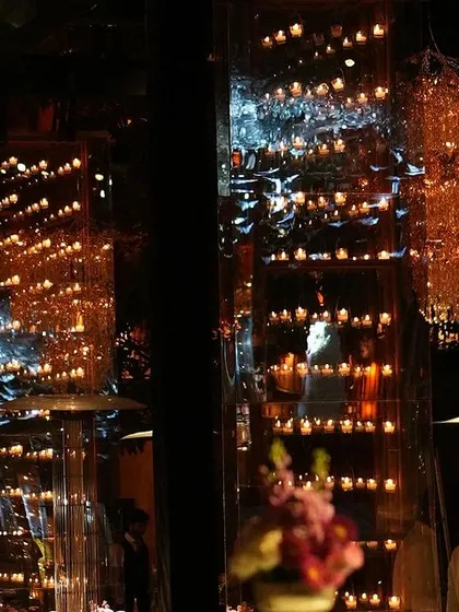 The venue was filled with the magic of candlelight, with mirrored walls reflecting the thousands of tiny flames, creating an infinite, sparkling effect.