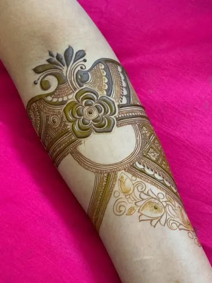 This arm band features a central flower with paisley elements, creating a symmetrical and jewelry-like effect.