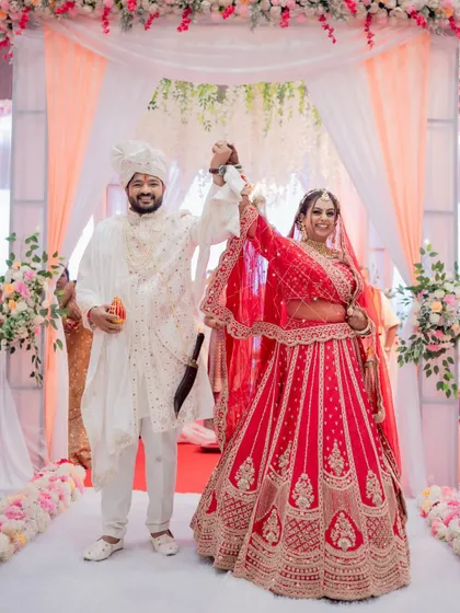 A triumphant and happy moment as the couple makes their entrance at the reception, holding hands high.