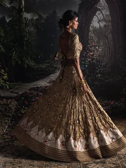 This Moonga silk lehenga, adorned with gentle brocade touches, resonates with a global yet distinct aesthetic, designed for the discerning bride who seeks understated opulence.
