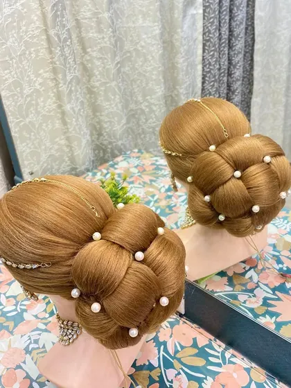 A beautifully executed 3D braided bun, decorated with pearls. This style teaches students how to create depth and dimension in their updos.