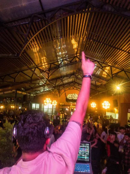 A view from behind the booth as I point to the sky, connecting with a packed venue. This shot captures the feeling of unity on the dance floor.