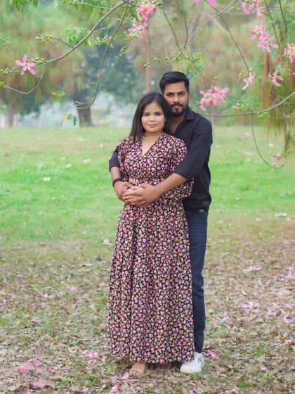 A full-length portrait of the couple during their pre-wedding shoot, showcasing their coordinated style and the beautiful outdoor scenery.