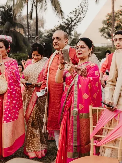 The family watches on, their faces filled with emotion and pride, as they document the ceremony on their phones.