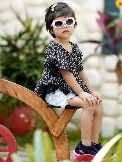 A cool and confident pose on a wooden bicycle prop. We have a wide range of props to make every outdoor shoot fun and unique.