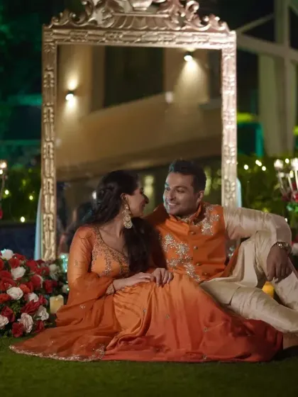The couple seated amidst a romantic setting of flowers and candles for their pre-wedding photoshoot.