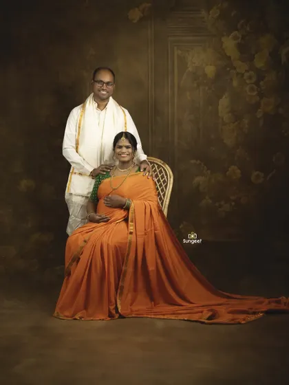 A formal portrait of the couple in traditional South Indian attire, perfect for a family album. The image is edited for a classic, painted look.