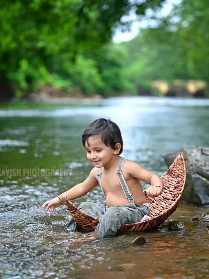A candid moment of the baby exploring the water during his outdoor nature shoot.