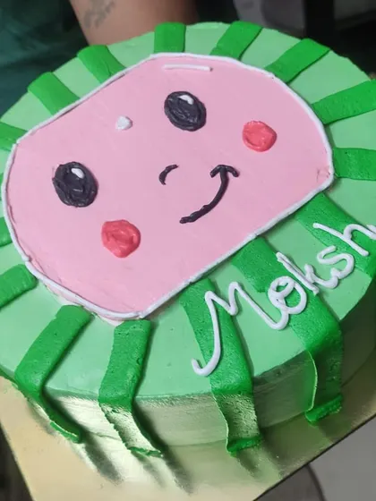 Perfect for a child's birthday, this Cocomelon theme cake brings the beloved character to life. The design is piped with bright green and pink buttercream for a fun and recognizable look.