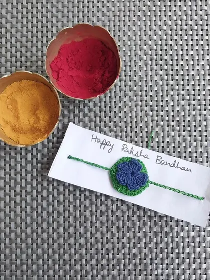 A two-toned crochet rakhi, combining green and blue. I can customize the colors to match your preference.