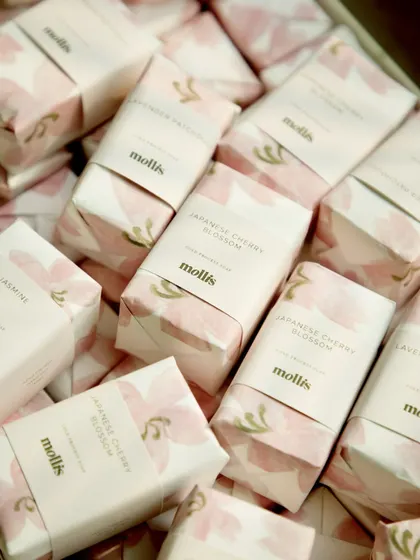 A custom order of 95 soaps for a baby announcement, featuring scents like Japanese Cherry Blossom and Lavender Patchouli, wrapped in a delicate pink floral paper.