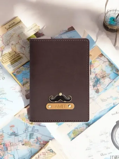A classic personalized passport cover in rich brown vegan leather. This one is customized for "Amit" with a fun mustache charm, adding a touch of personality to his travel essentials.