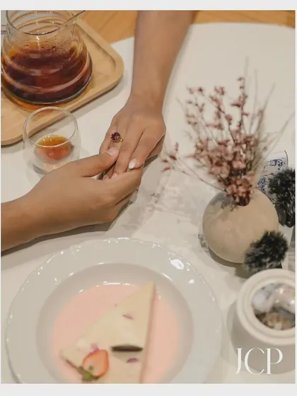 A close-up detail shot of the couple's hands, focusing on the engagement ring and the promise of their journey together.
