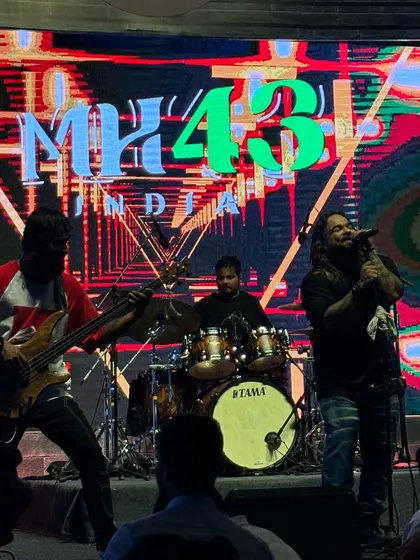 The full band setup with vibrant, abstract visuals on the LED screen. We love to create a complete audio-visual experience at our corporate shows.