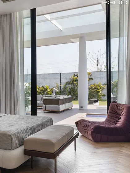 This bedroom opens directly onto a private patio and pool area, blurring the line between inside and out. Waking up to soft sunlight and a beautiful view is the ultimate luxury we design for our clients.