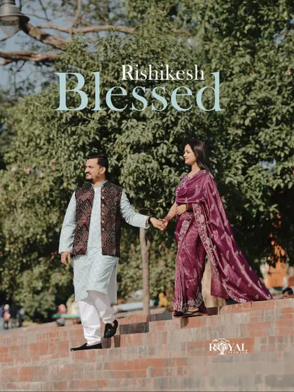 A graceful shot of a couple in beautiful traditional attire walking down the steps of a ghat, capturing a blessed moment.