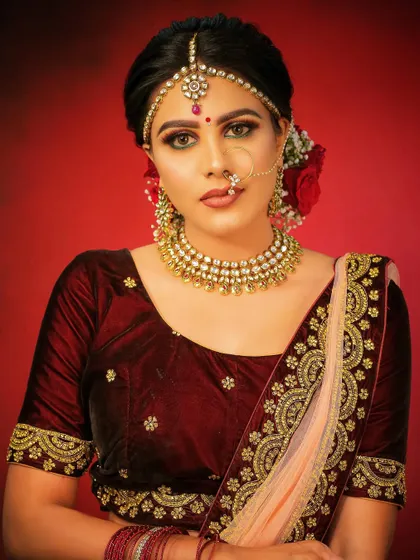 A beautiful model wearing a traditional Kundan choker and matha patti. This look is perfect for a bride who wants a classic and elegant style for her wedding day.