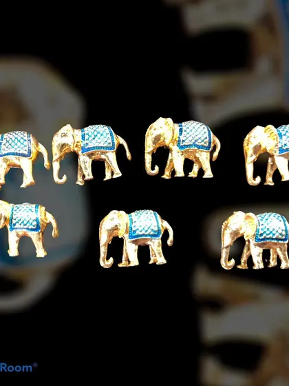 A set of designer buttons shaped like elephants with blue enamel detailing. These unique, gold-tone buttons are perfect for adding a touch of royal Indian heritage to a bandhgala or sherwani.