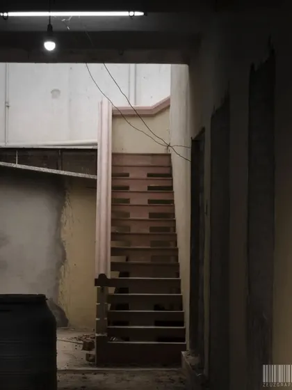 A staircase in a dimly lit, rustic building. The composition and lighting create a sense of mystery, leaving you to wonder where it leads.