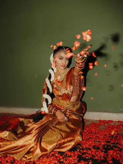 A bride in her traditional South Indian wedding saree, adorned with temple jewelry and a jasmine braid. We help coordinate these details to ensure a timeless and culturally rich bridal look.