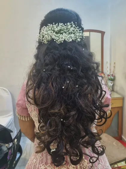 An open-hair style with lots of volume and curls. We decorated it with colorful baby's breath for a whimsical and romantic party look.
