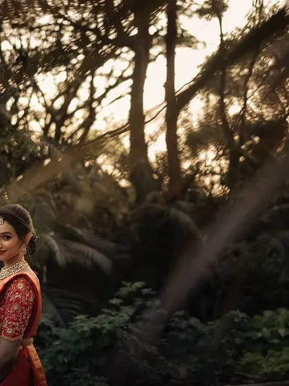 A bride in the woods, caught in the golden hour light. The natural setting and the warm sunlight create a soft, romantic mood for this beautiful outdoor portrait.
