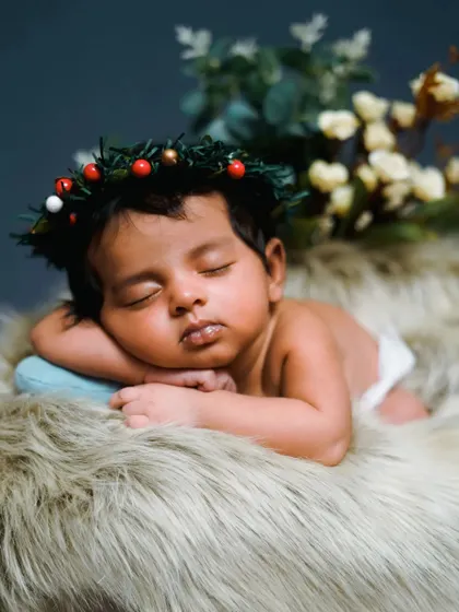 A Christmas-themed newborn shoot with a tiny wreath. This is a wonderful way to celebrate your baby's first holiday season.
