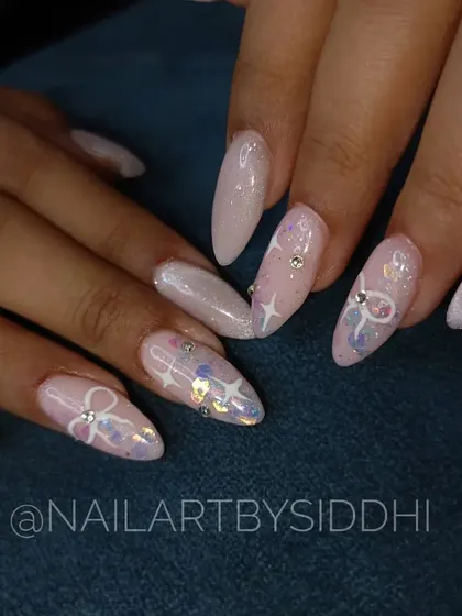 A soft and ethereal look, this set features a shimmery, light pink base with hand-painted bows, stars, and scattered rhinestones.