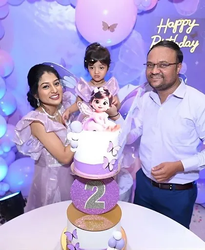 A happy family celebrating their daughter Saiyami's second birthday with our butterfly-themed cake.