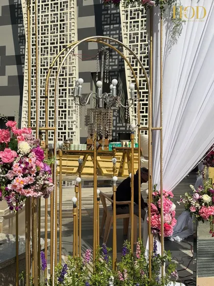 A detail shot of the golden archway and chandelier used in the entrance decor. The combination of the metallic finish and crystal elements creates a look of sophisticated luxury.