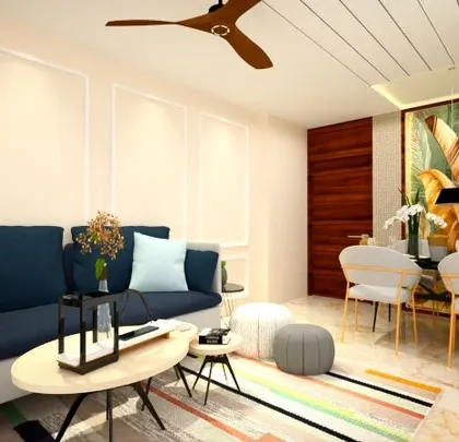 A proposed design for a living room with a deep blue sofa and a colorful rug. The wall features simple molding, and the dining area is highlighted by a large, artistic painting.