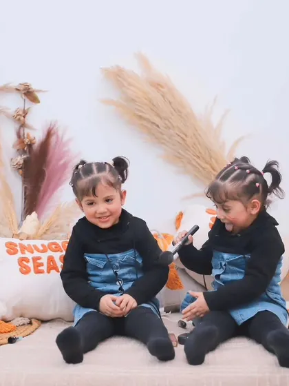 A candid moment of the twins playing and interacting during their fun studio session.