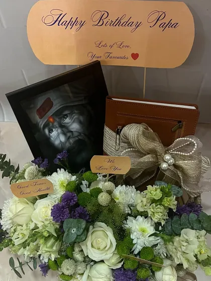 This view shows the leather-bound journal included in the spiritual-themed birthday hamper, perfectly complementing the portrait and serene flowers.