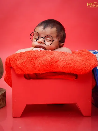 A close-up of our little reader. Even while sleeping, this baby looks wise beyond his days in this adorable themed setup.