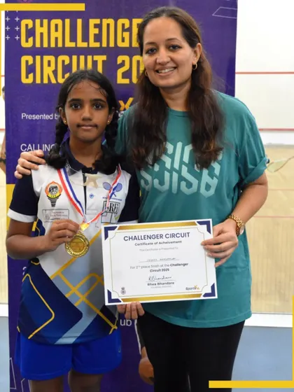 A young athlete proudly displays her medal and certificate of achievement at the Challenger Circuit awards ceremony.