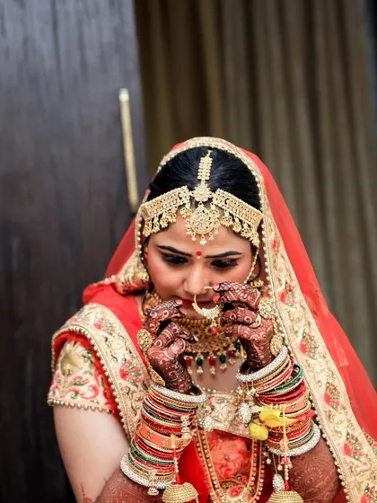 A candid getting-ready shot of a bride adjusting her nose ring. These small, focused moments are a beautiful part of the wedding day story.