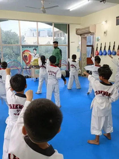 A view from the back of the class, showing students practicing their blocks.