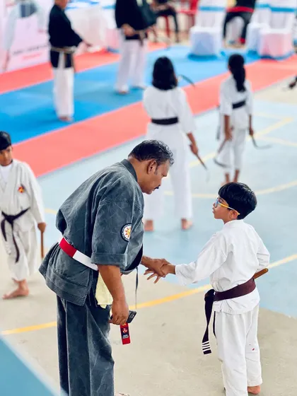A moment of respect between a master and a young student during the Kobudo weapons seminar.